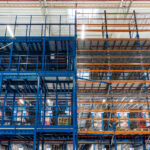 Metalowe regały wysokiego składowania w hali magazynowej e-commerce, wspierającej logistykę i kompletację zamówień online